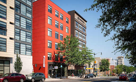 A red building with a tree in front of it.