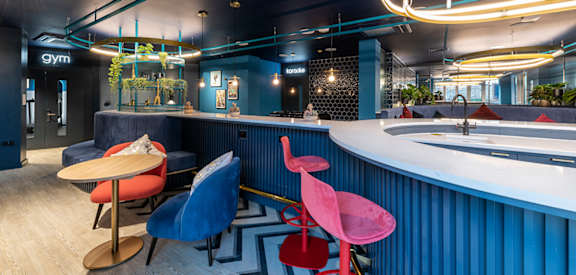 a bar and tables in a room with blue walls and a sink