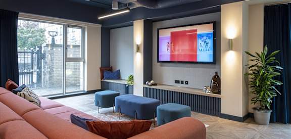 a living room with a pink couch and a tv