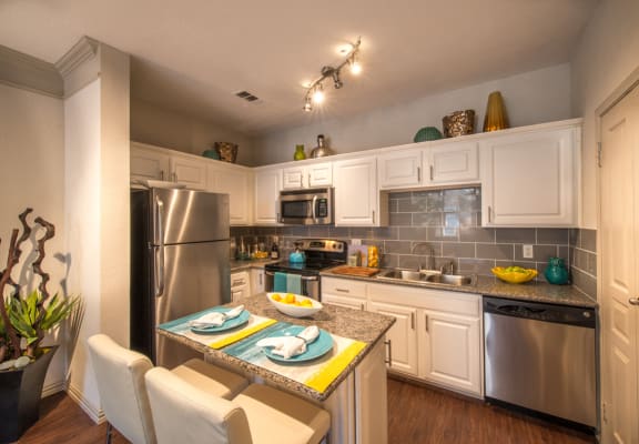 This is a photo of the kitchen area of the 826 square foot 1 bedroom  apartment at The Brownstones Townhome Apartments in Dallas, TX.