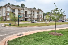 Apartment complex with a green sign in front of it.