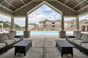 A large outdoor patio with a pool and couches.