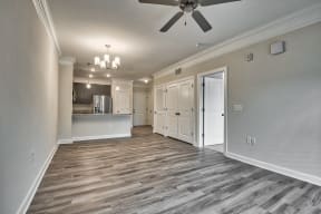A spacious room with a ceiling fan and wooden flooring.