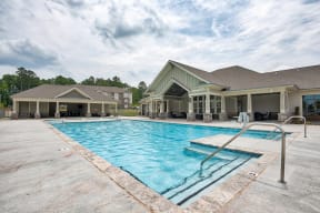 A large outdoor swimming pool with a diving board.