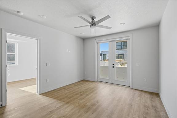A room with a ceiling fan and a view of a building outside the window at Brickside Heights, Millcreek, 84106