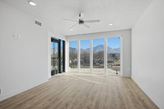 A room with a ceiling fan and sliding glass doors at Brickside Heights, Millcreek, 84106