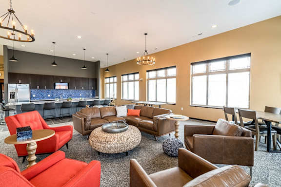 a clubhouse with couches chairs and a bar and a kitchen