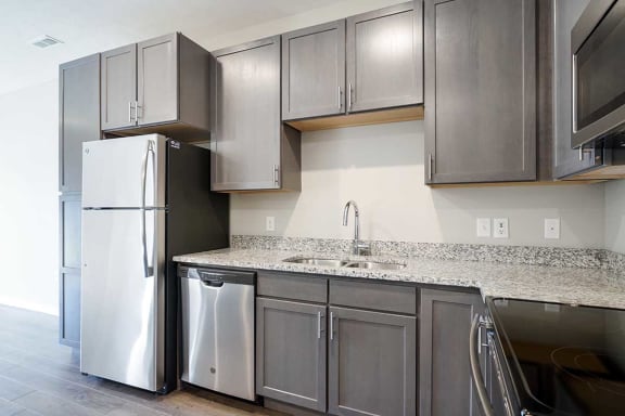 a kitchen with stainless steel appliances and grey cabinets