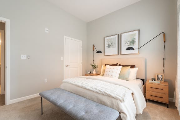 a bedroom with a bed and two pictures on the wall
