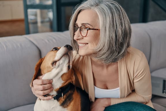 a woman sitting on the floor petting a small dog