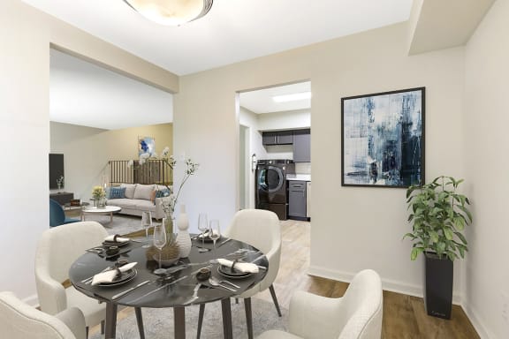 a dining area with a table and chairs and a living room in the background at Copper and Quarry Village, Pikesville, MD, 21209