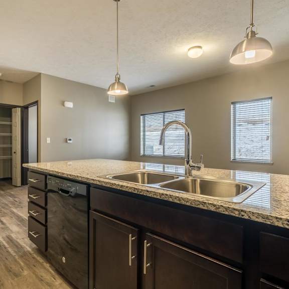 A kitchen with a sink and a refrigerator.