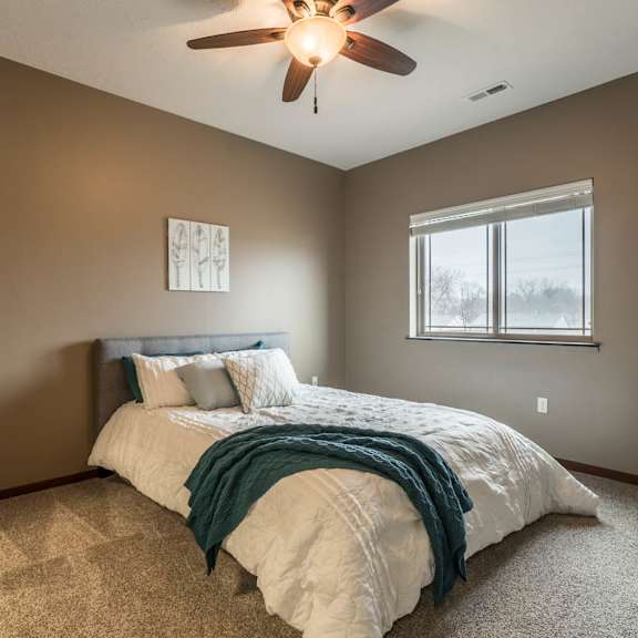 a bedroom with a bed and a ceiling fan