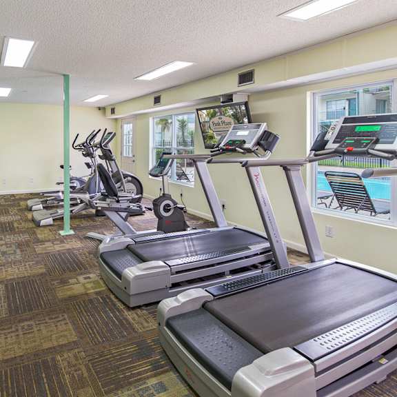 A gym with treadmills, elliptical machines, and other exercise equipment.