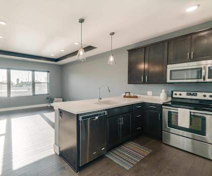A modern kitchen with stainless steel appliances and wooden cabinets.