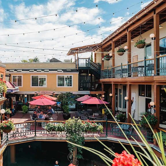 A patio with tables and chairs and umbrellas.