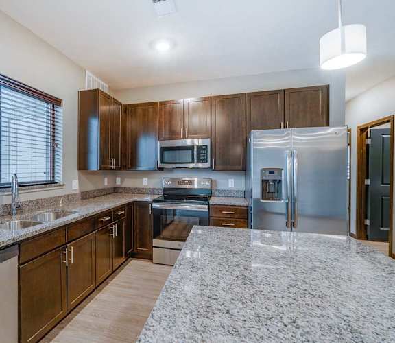 a kitchen with granite counter tops and stainless steel appliances