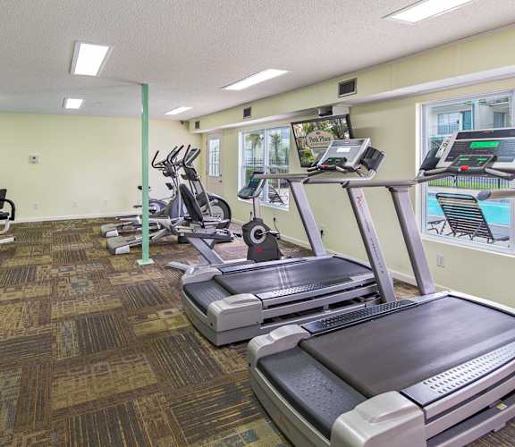 A gym with treadmills, elliptical machines, and other exercise equipment.