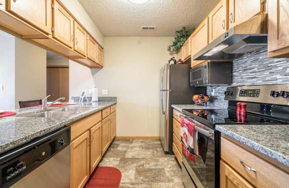 A kitchen with granite countertops and stainless steel appliances.