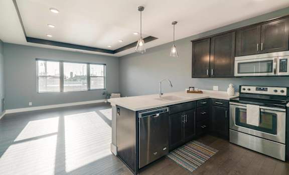 A modern kitchen with stainless steel appliances and wooden cabinets.