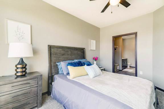 A modern bedroom with a bed and nightstands, and an attached bathroom.