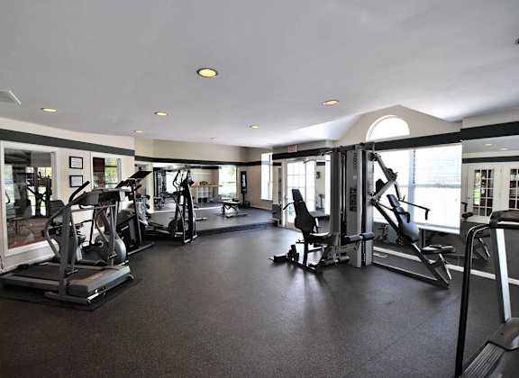 the gym has plenty of equipment and a view of the city at Village Club on Franklin, Southfield Michigan