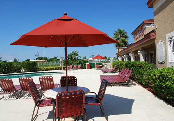 Oaks at Pompano table with umbrella near pool