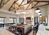 Thumbnail 20 of 25 - Elegant resident clubhouse featuring soaring ceilings, exposed wood beams, a modern fireplace, and comfortable lounge seating.