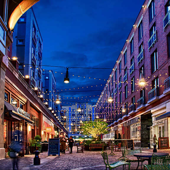 a city street at night with a string of lights hanging over the street