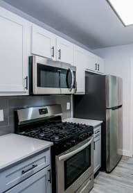 a kitchen with white cabinets and stainless steel appliances