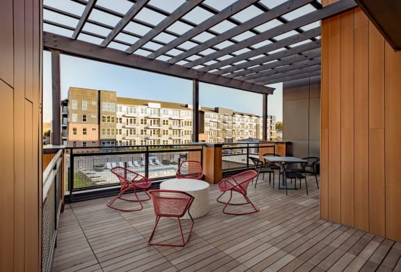 a rendering of a balcony with red chairs and tables
