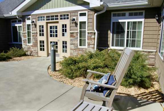 A chair is in front of a house.