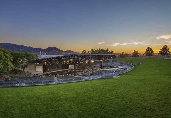 a view of a stadium at sunset with mountains in the background
