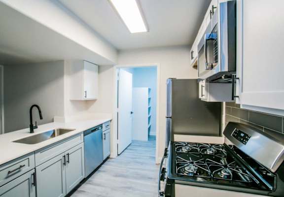 a kitchen with white cabinets and stainless steel appliances