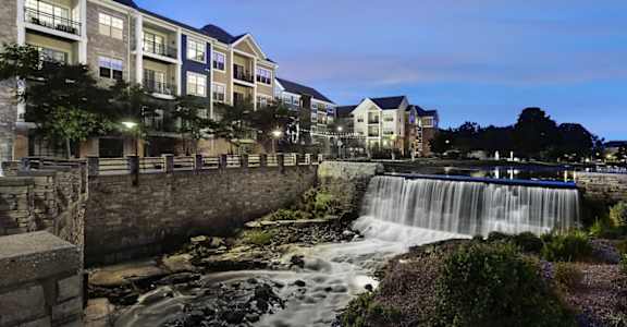 a waterfall in front of a building at night