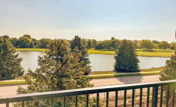 a balcony with a view of a lake and trees