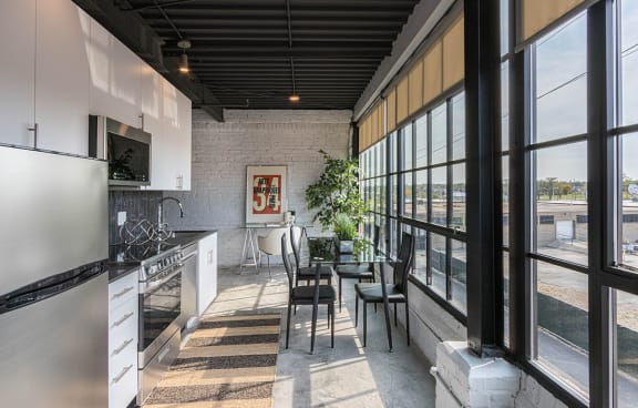 a kitchen and dining area with large windows and a table and chairs