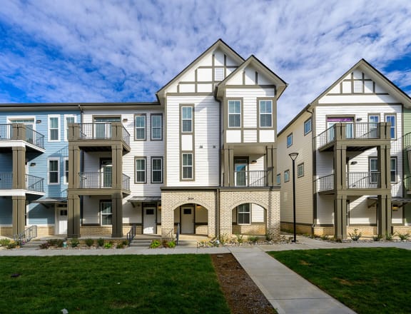 an exterior view of an apartment building with a sidewalk and grass  at Oakbrook Townhomes, Franklin, Tennessee