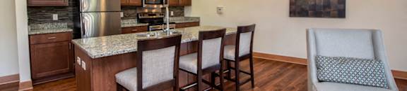 a kitchen and living room with a bar and chairs
