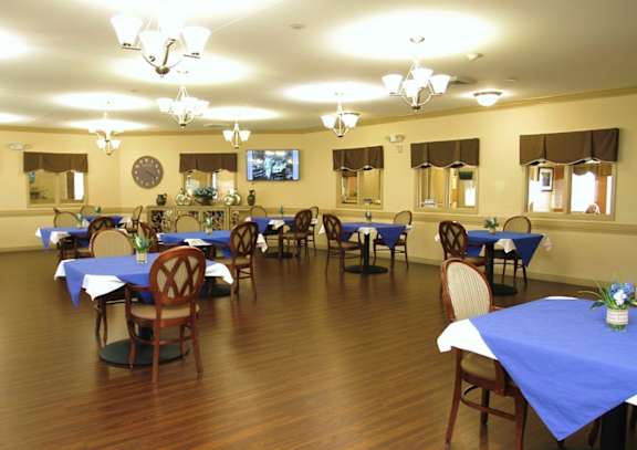A dining room with tables and chairs set up.