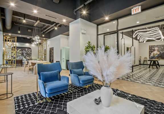 a lobby with blue chairs and a white table