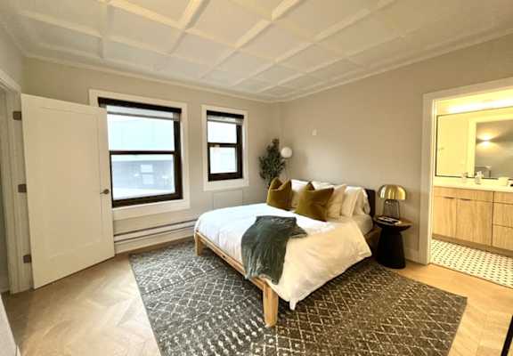 a bedroom with a bed and a rug