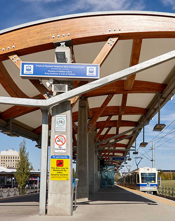 A train station with a blue sign that says "No Parking" and a yellow sign with a red border.