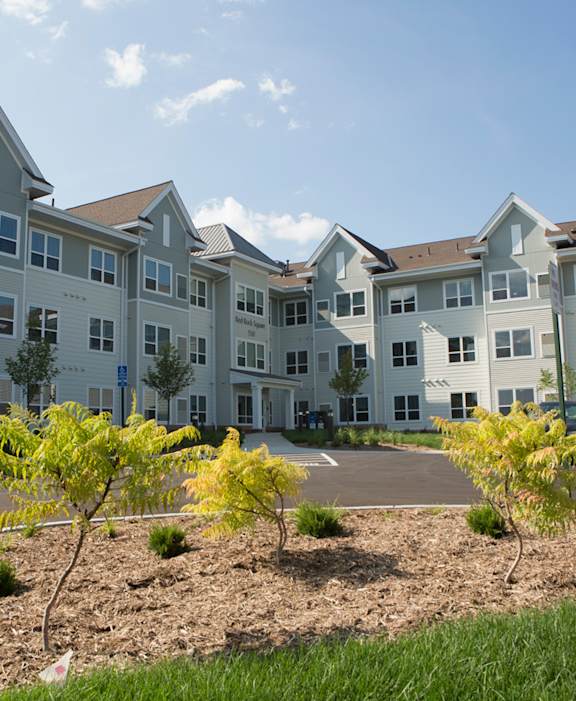 Apartment complex with trees in front.