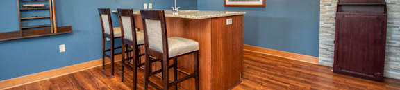 a living room with a bar and a blue wall and wood floors