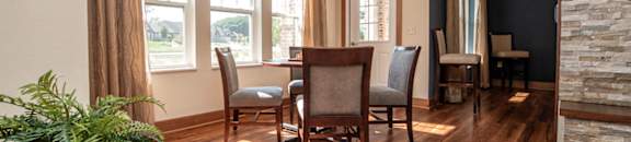 a dining room with a table and chairs on a wood floor