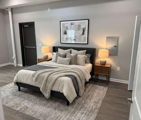 A bedroom with a large bed and a painting on the wall.