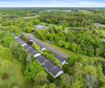 A long row of houses with trees in the front.