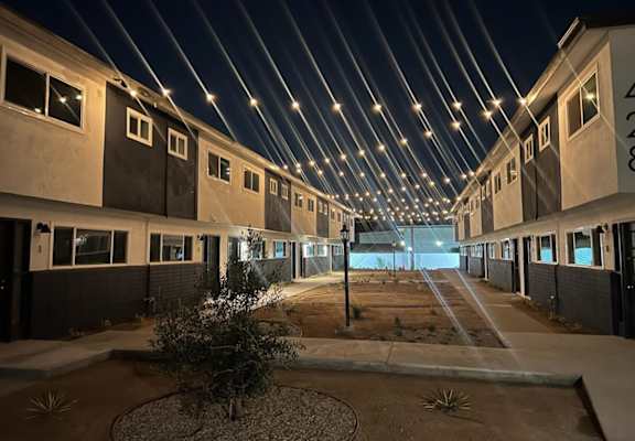 the buildings are lit up at night with lights hanging from the ceiling