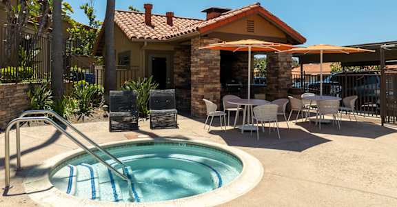 A pool with a slide and a house in the background.